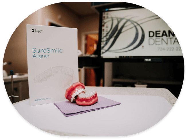 Model of teeth on table with SureSmile clear aligner kit
