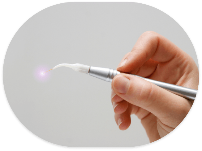 Hand holding a small silver dental laser device