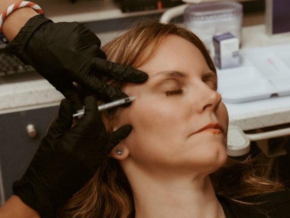 Man receiving Botox between his eyes