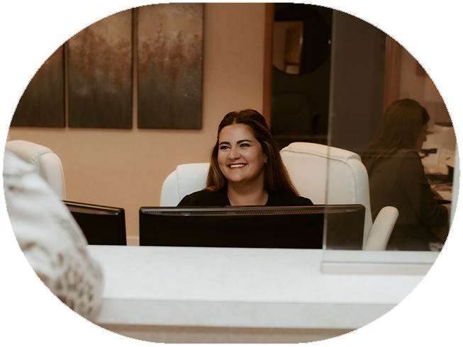 Two smiling team members at front desk