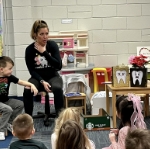 Dental team member reading to a classroom of kids