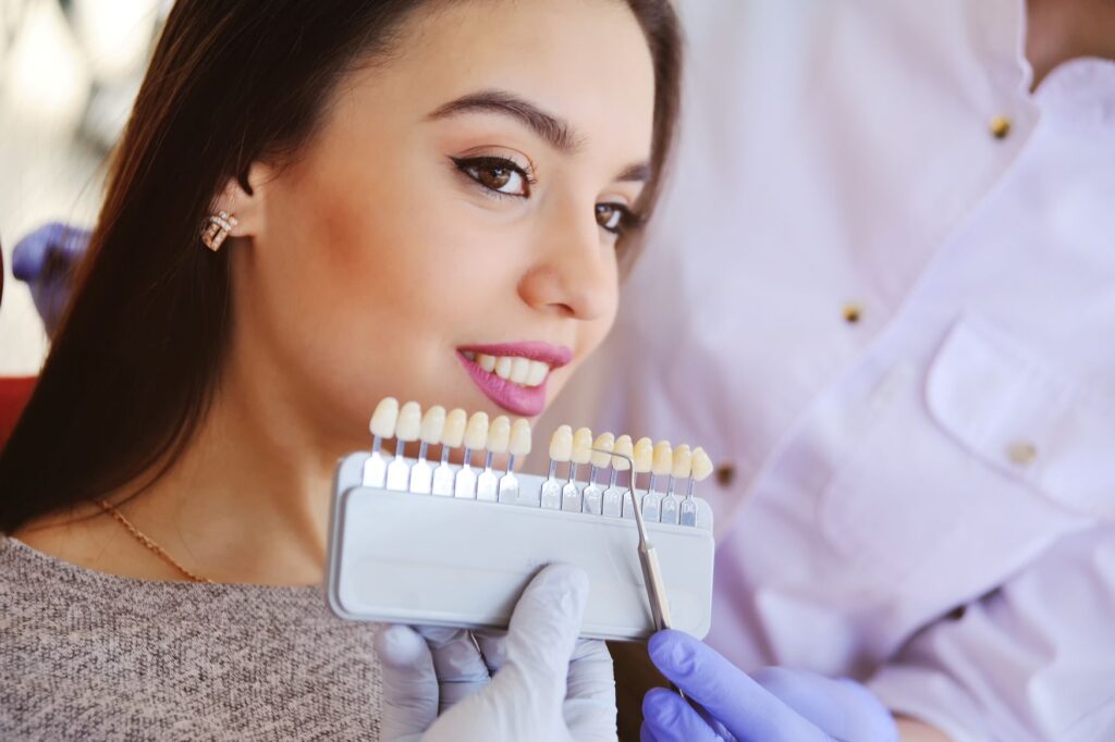 Shade guide held to woman's smile