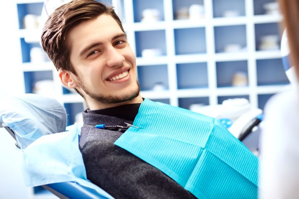 A young man smiling in a dental chair